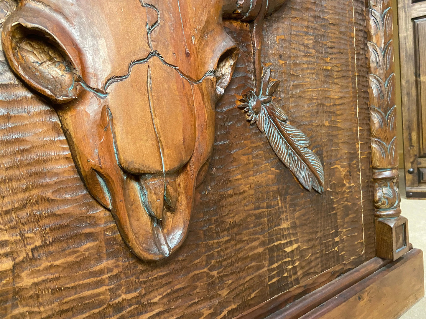 Detailed close up of hand carved cow skull & feather on the front of the Cowboy Western Home Bar