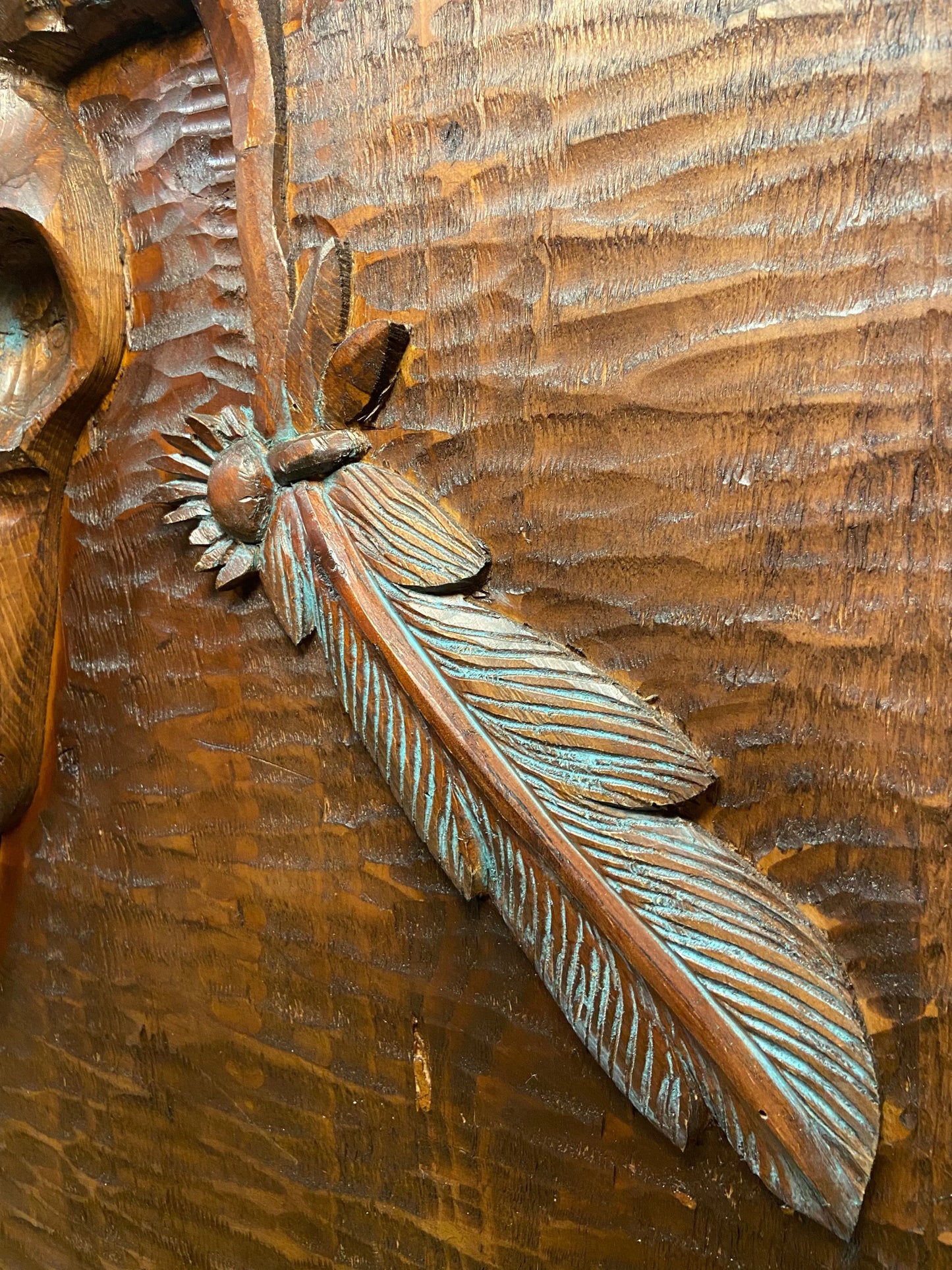 Close up angled view of hand carved feather.
